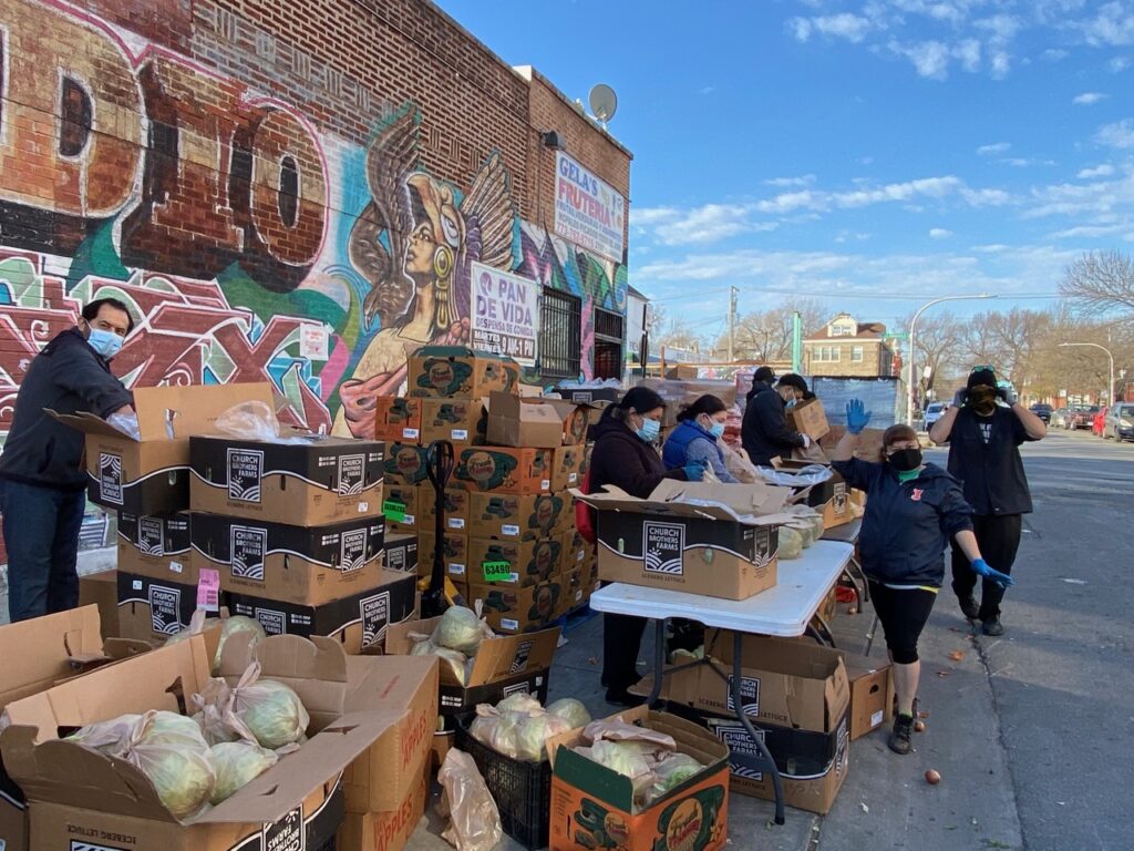 A group photo of people handing out food at a food drive.